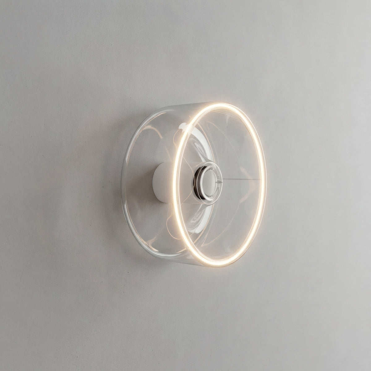 Bombilla LED donut E27 de cristal transparente, Ø 195 mm, encendida como aplique de pared en un interior sobrio