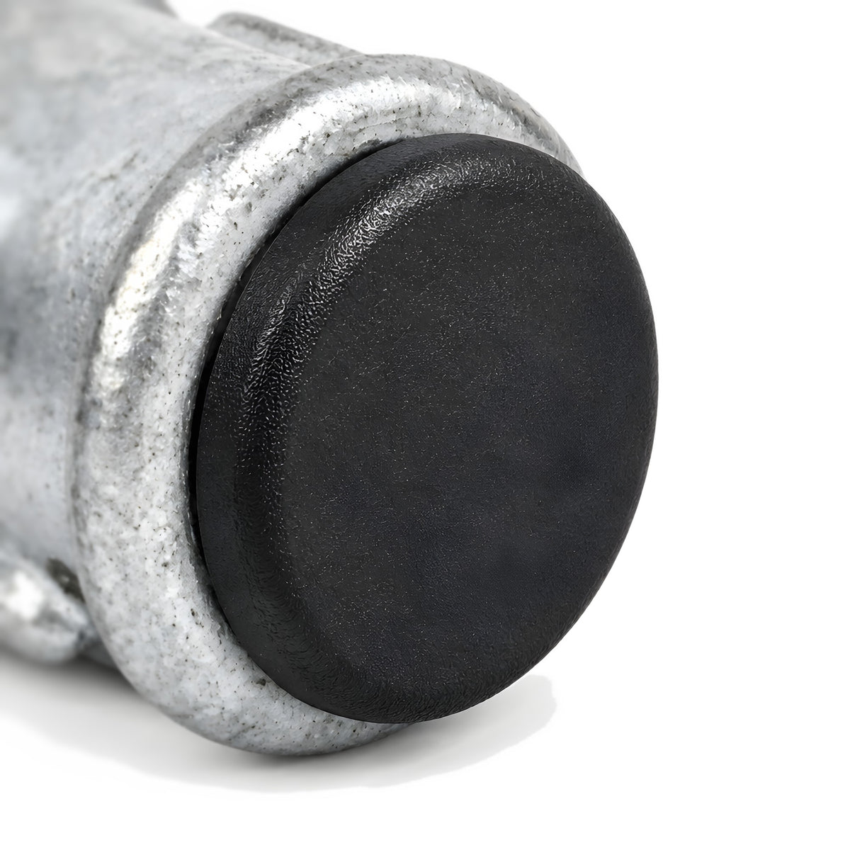 Tapón de plástico negro cerrando la abertura de un manguito de hierro fundido galvanizado