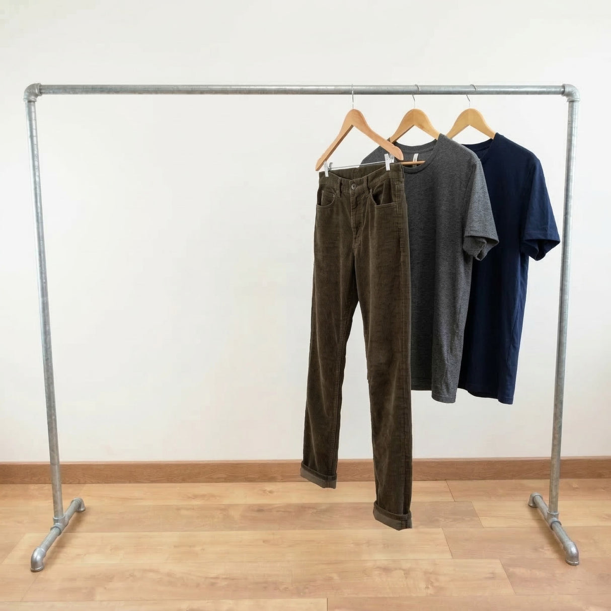 Perchero galvanizado cargado de ropa en perchas