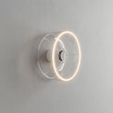 Bombilla LED donut E27 de cristal transparente, Ø 195 mm, encendida como aplique de pared en un interior sobrio