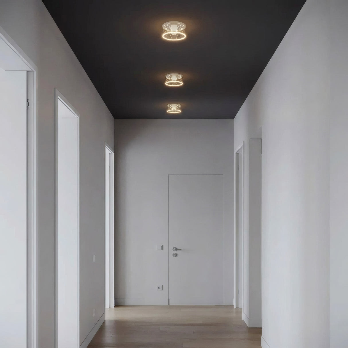 Tres bombillas LED donut E27 de cristal transparente alineadas en el techo de un pasillo sobrio