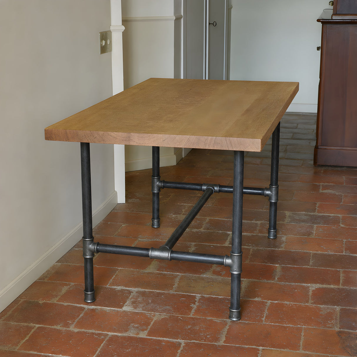 Base de mesa de comedor, hierro fundido y acero barnizado, en H Ø 34 mm, en situación bajo un tablero de roble en bruto de sierra