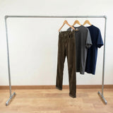 Perchero galvanizado cargado de ropa en perchas