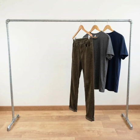 Perchero galvanizado cargado de ropa en perchas