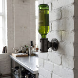 Soporte de pared para botella de fundición en una pared de ladrillo pintado de blanco en una cocina industrial, botella de vino sujeta por el cuello